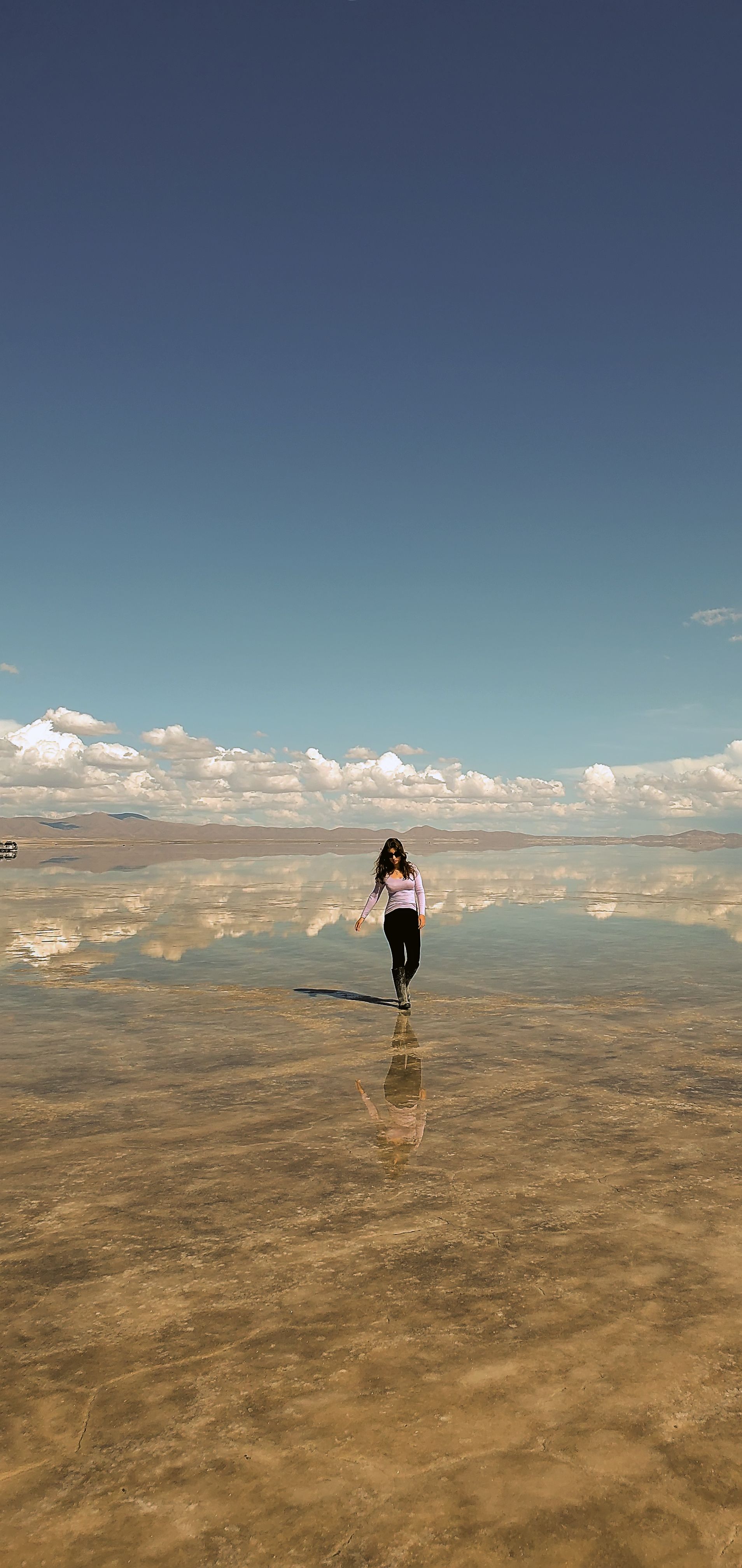 Sofia walking across the mirror-like Bolivian salt flats